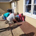 Volunteers Laying Down Weed Fabric In Flower Bed #1 During 2022 Clean Up Day