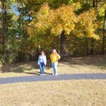 Two people standing on paved walking track