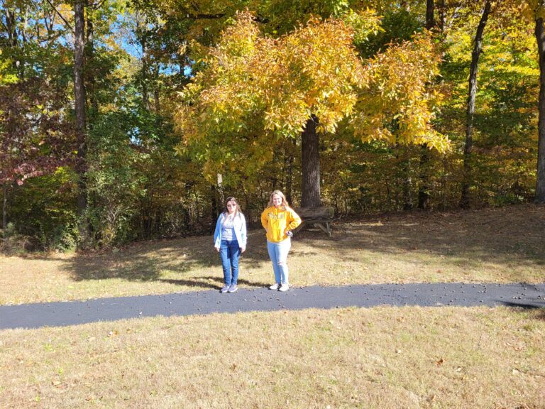 Two people standing on paved walking track